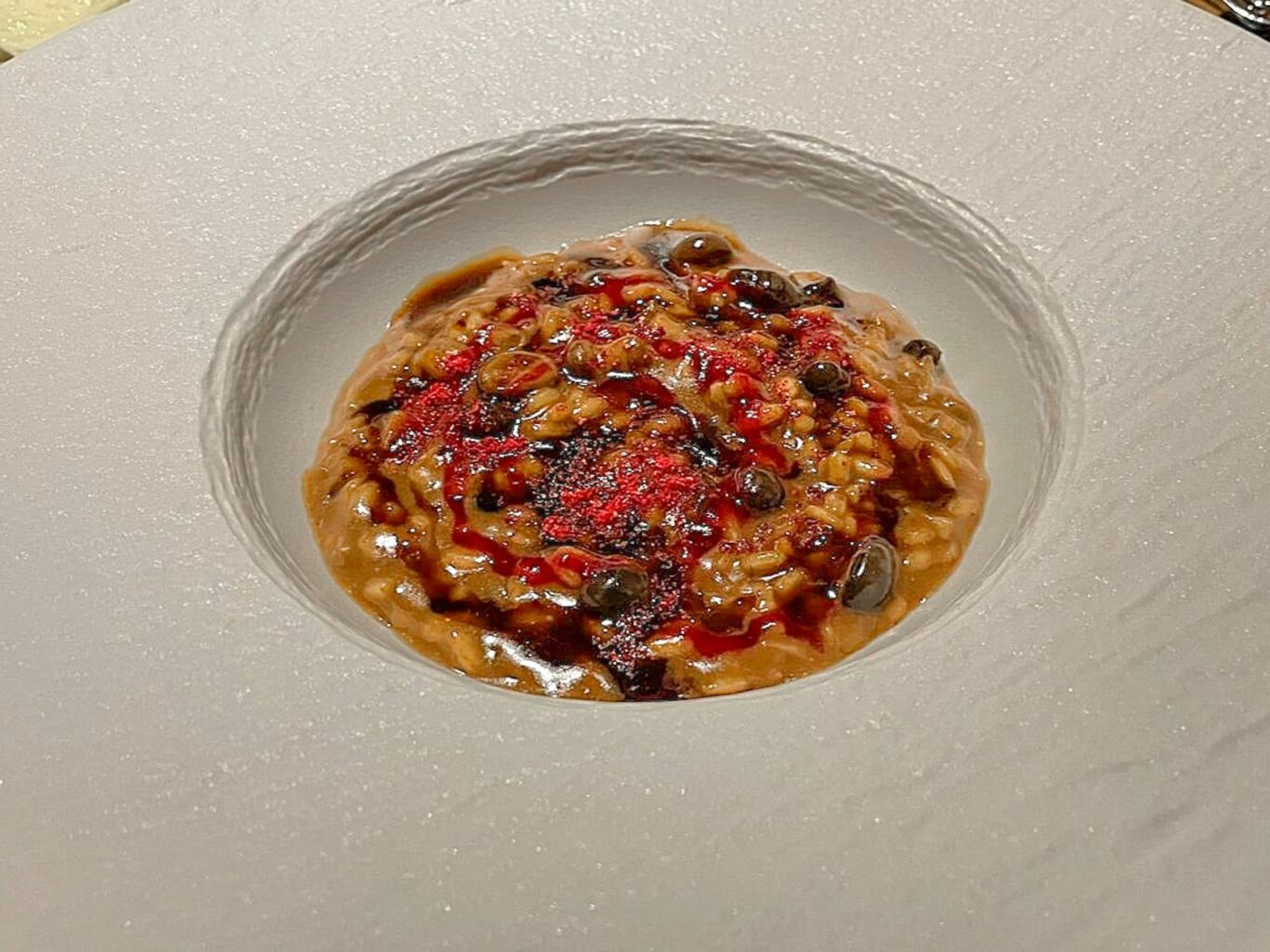 Riso cotto in estrazione di funghi, aglio nero, mirtillo rosso e burro nocciola.