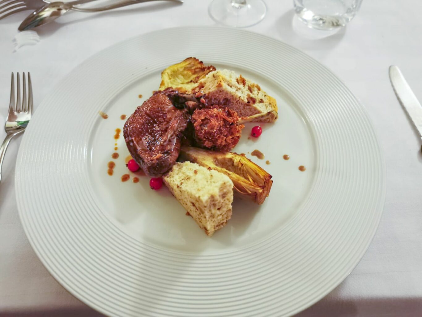 Piccione petto e coscia, carciofi, pane alle noci e ribes della trattoria Ai Due Platani