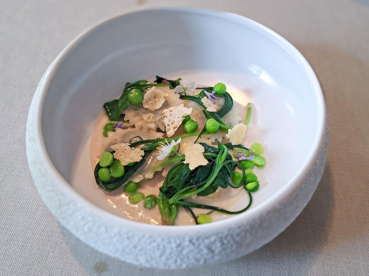 Ravioli bianchi di pasta acida, erbe spontanee e noci del ristorante All'Enoteca.