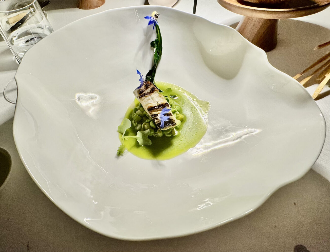 Branzino alla brace, passatina di porri, cetriolo e piselli.