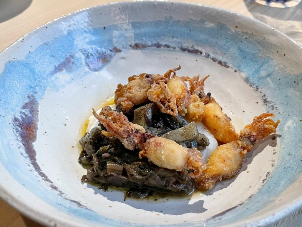 Calamaretti spillo con erbe amare, brodetto di canocchie e fegati di rana pescatrice – Inverno 2024 del ristorante Le Calandre.
