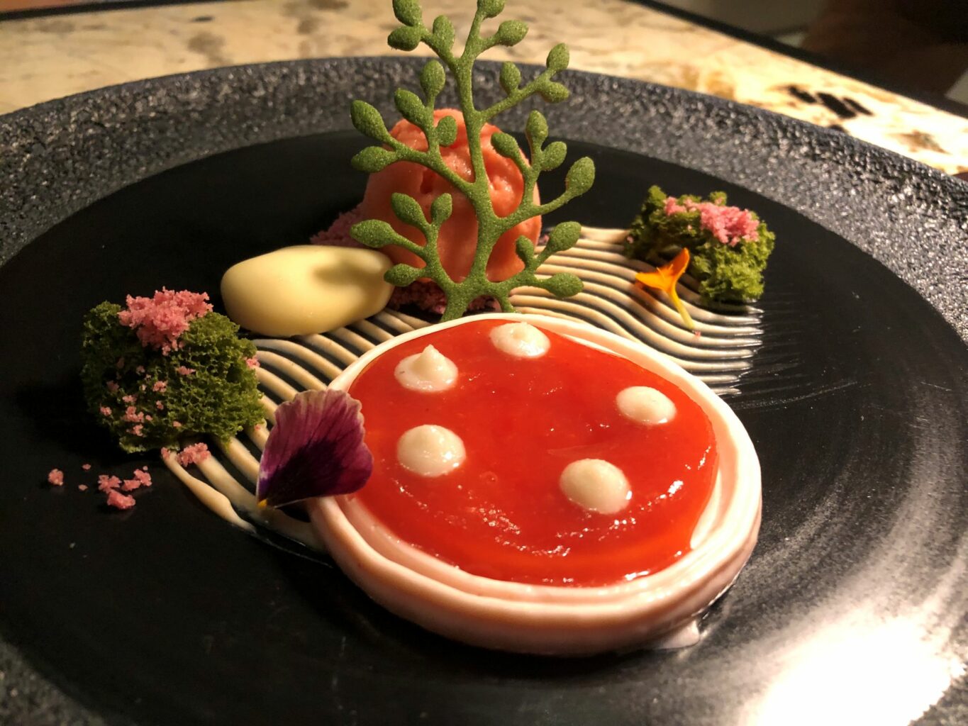 Giardino zen panna cotta alle mandorle, gel di fragole e mandorle, sorbetto alla fragola, namelaka cioccolato bianco e mandorla, pan di Spagna e alberello al tè matcha.