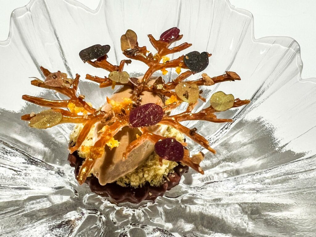 Tartelletta di noci pecan con carciofo arrostito alla cenere, caramello e gelato ai frutti neri.