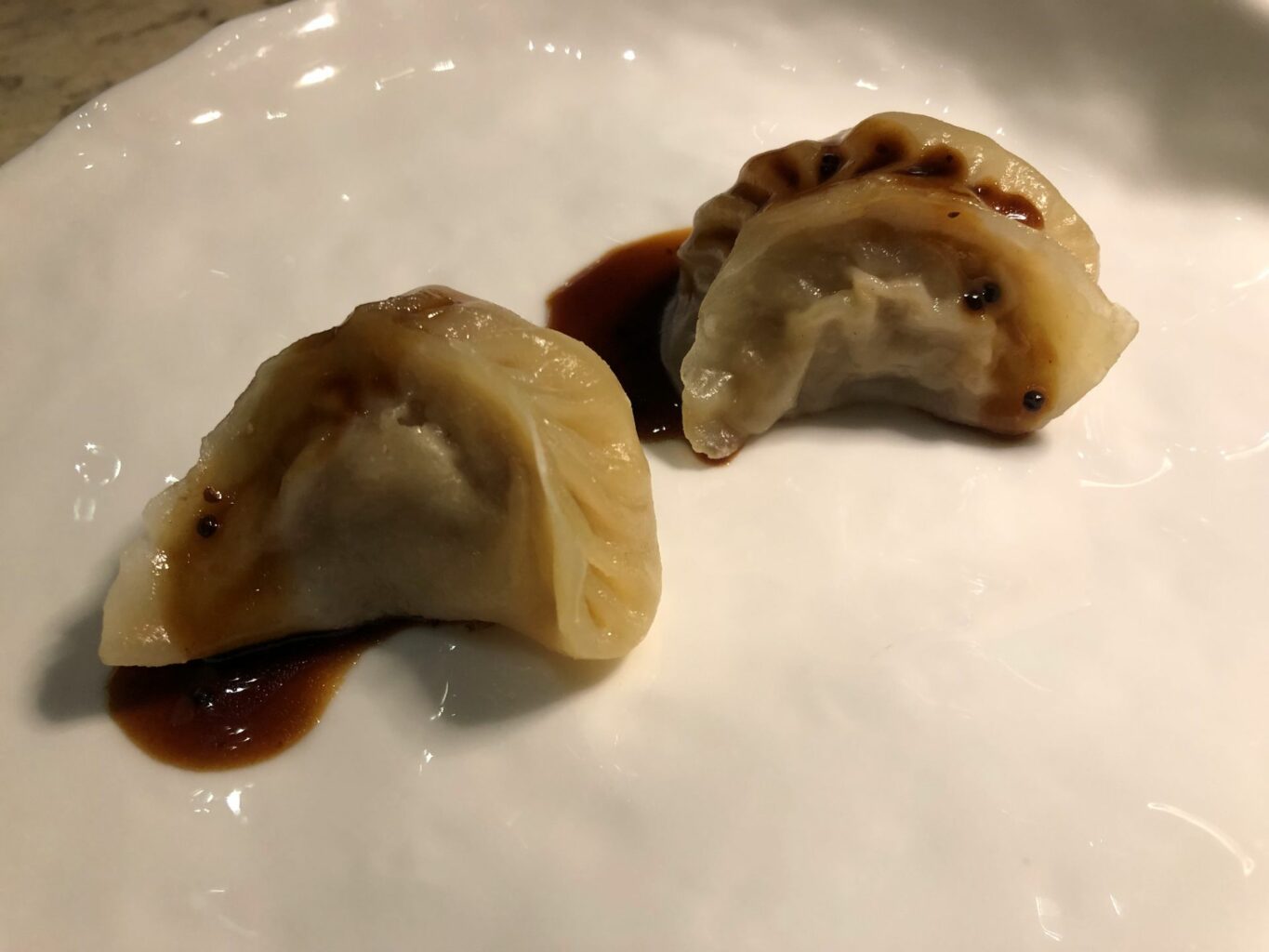 Ravioli classici con maiale e cavolo cappuccio su emulsione di soia.