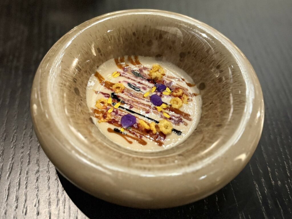 Crema di patate con salsa ai ricci di mare, salsa al nero di seppia e mais.