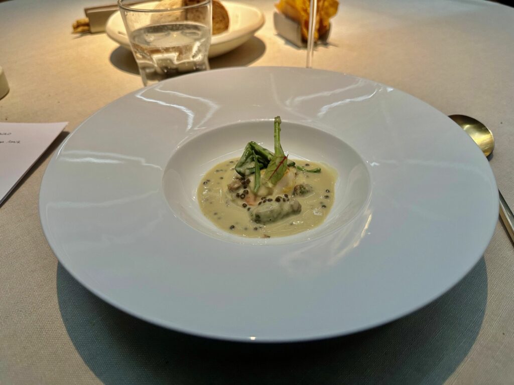 Capasanta al burro di cacao, salsa al vermouth, fagioli e caviale dell'antica osteria cera.
