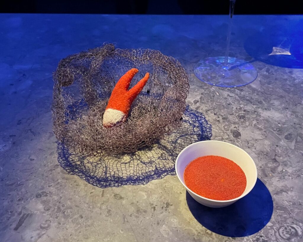 Lobster Claw: La chela congelata viene immersa in una miscela di vodka e amido di mais: durante la frittura, la vodka evapora, lasciandoci una panatura estremamente croccante. La chela stessa è fatta con chele e code di aragosta danese cotte nel burro. È spolverata con pomodoro fermentato e servita con una salsa al burro e rafano.