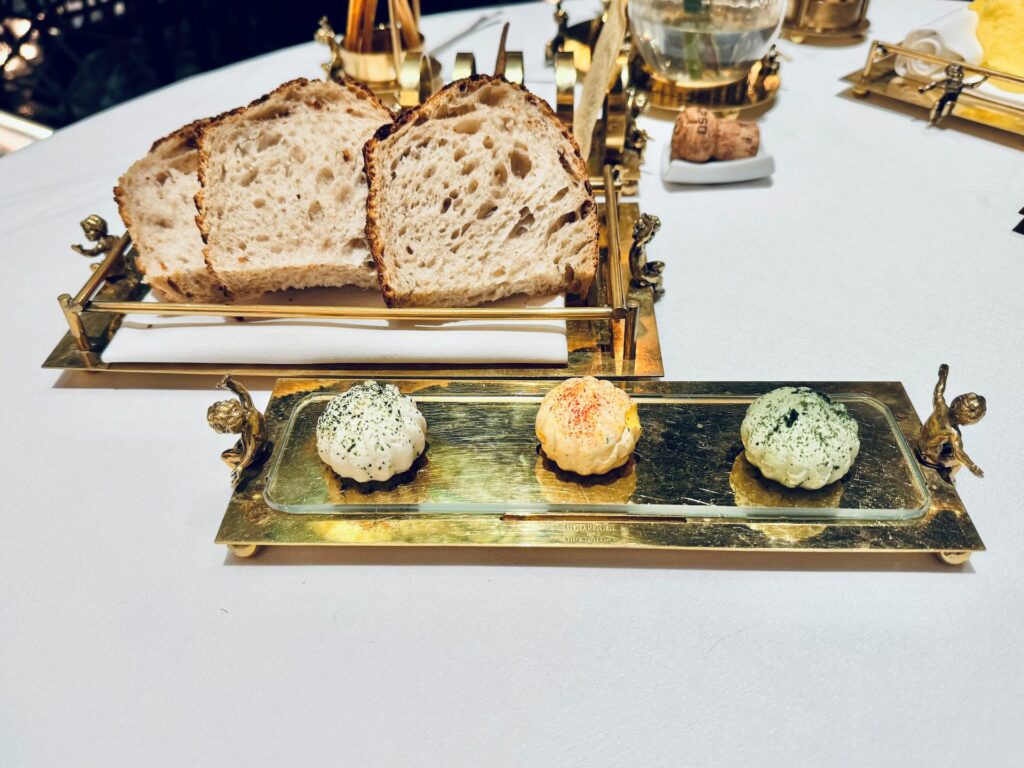 Il servizio del pane con burro aromatizzato alla menta, allo zafferano e al plancton.