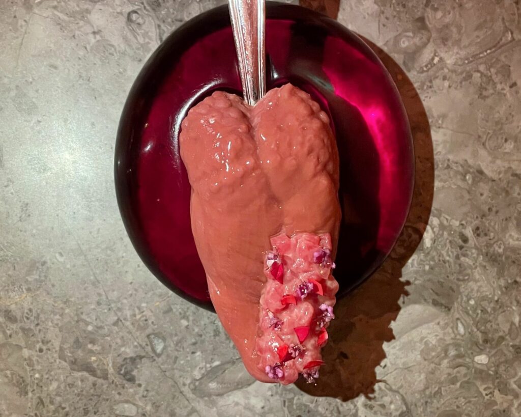 Tongue Kiss: la lingua è guarnita con una tartara di manzo a zero emissioni di carbonio, mango acerbo e limoni salati. Piatto iconico dell'Alchemist.