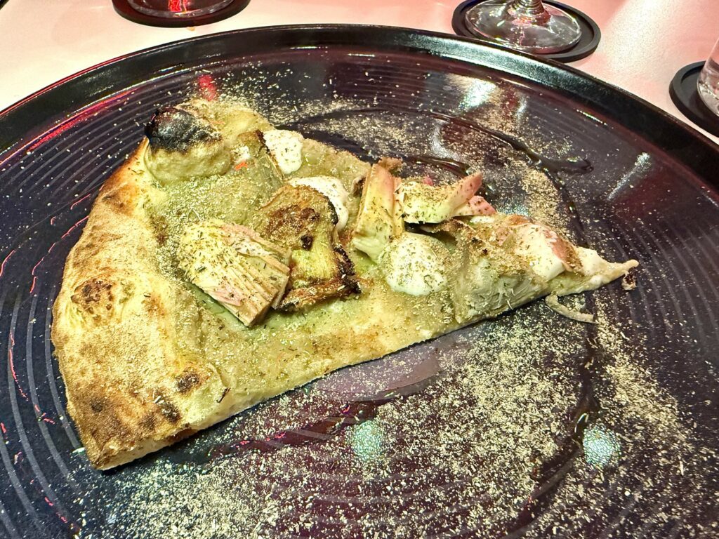 Pizza assoluto di carciofo: crema di carciofo, carciofo gratinato, carciofo marinato, polvere di carciofo e mousse al parmigiano.