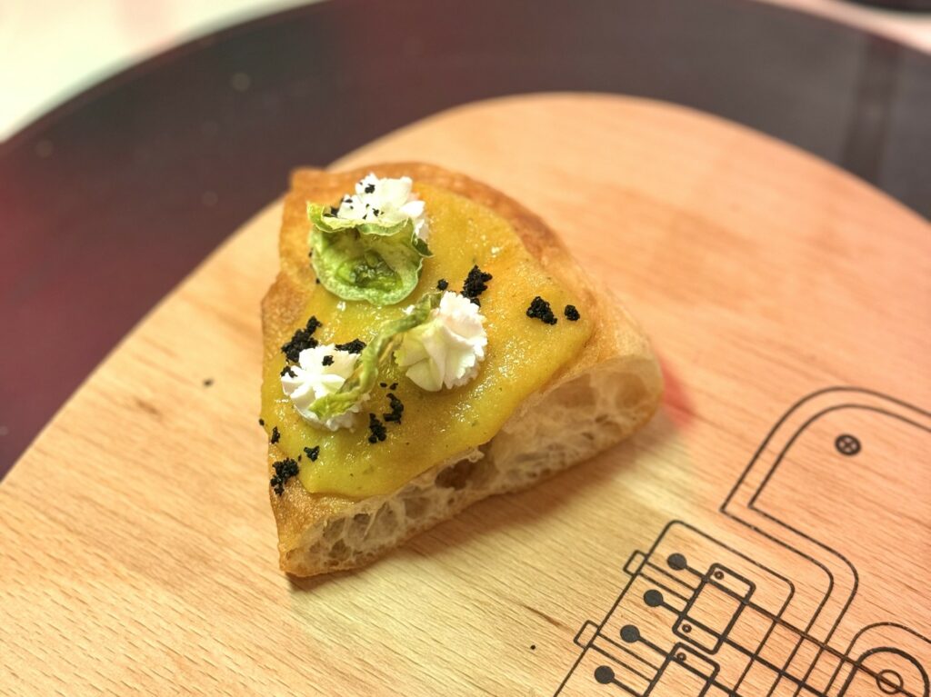 Pizza fritta twist: pomodoro verde in due consistenze, caprino e aglio nero della pizzeria Quattro Quarti.