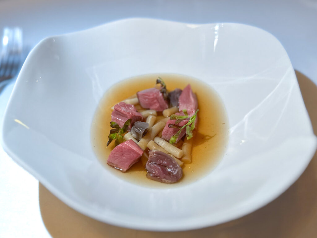 Piccione arrostito, passatelli, consommé di verbena, liquirizia dello chef Stefano Baiocco.