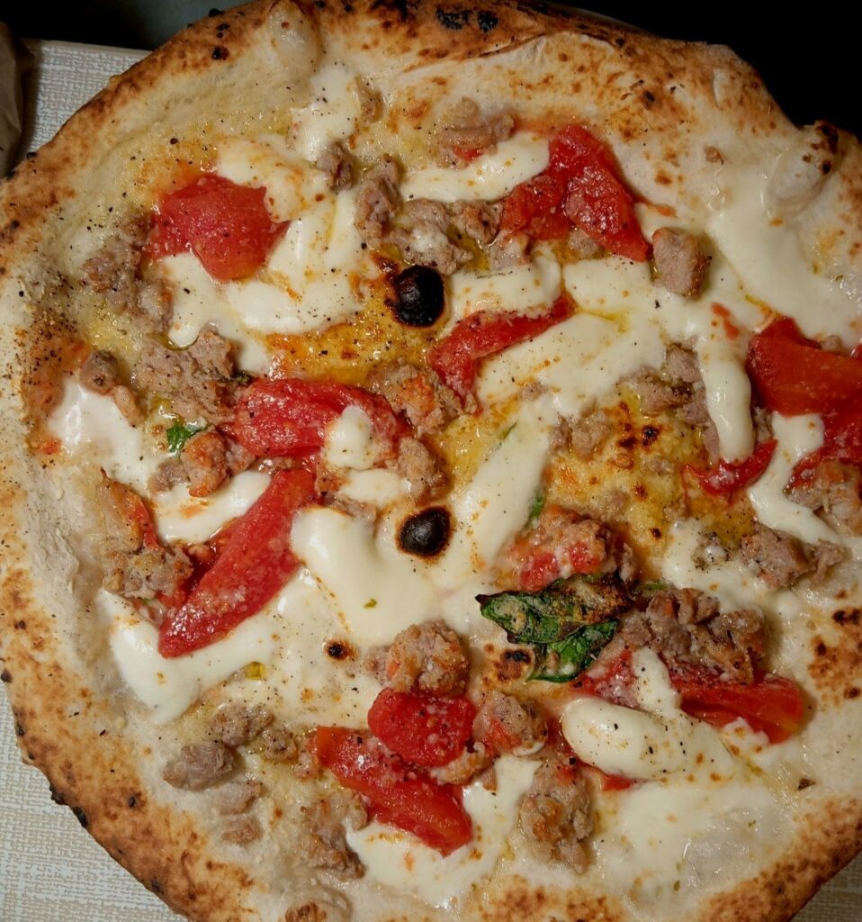 Capodimonte: pomodoro, provola, salsiccia, olio evo, pecorino, basilico e pepe de La Notizia 53.