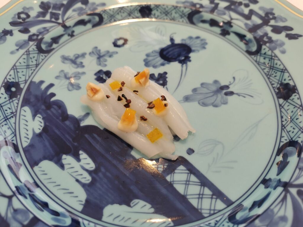Torrone marino. Bianco di seppia marinato zucchero e sale, arancia, nocciola e fava di cacao.