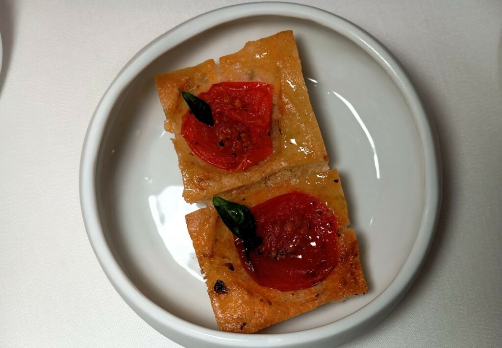 Focaccina fatta in casa con pomodorino, origano e basilico del Ristorante Don Alfonso.