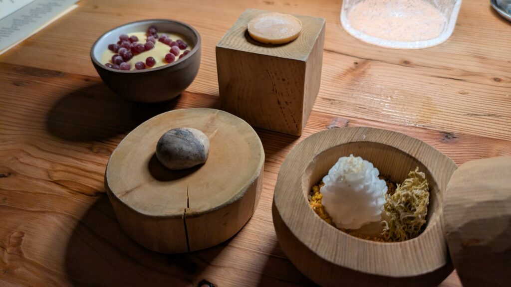 Miniature wild dolci del ristorante El Molin: caramella al latte; sasso al geranio odoroso; pane, formaggio, bacche dolci e amaro; borderline.