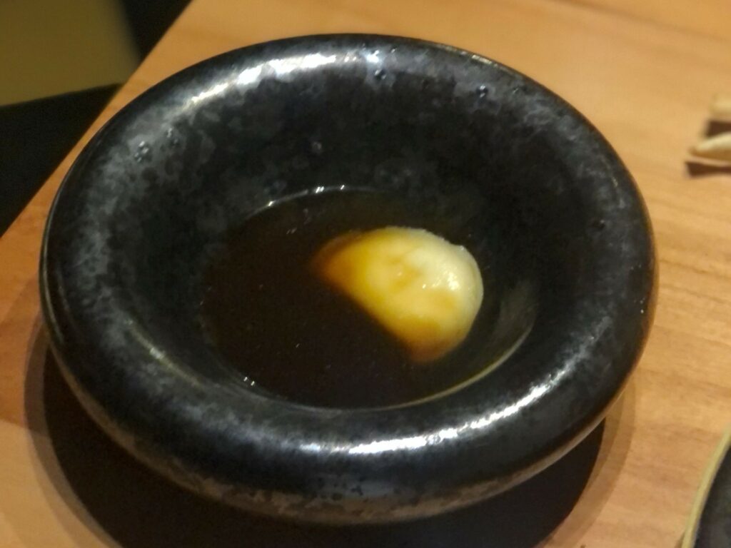 …Consommé di cipolla e raviolo ripieno di taleggio e olio di cipolla bruciata.
