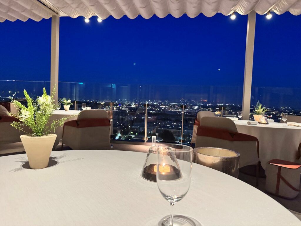Ci accomodiamo al tavolo del ristorante la pergola scorgendo Roma dall’alto.