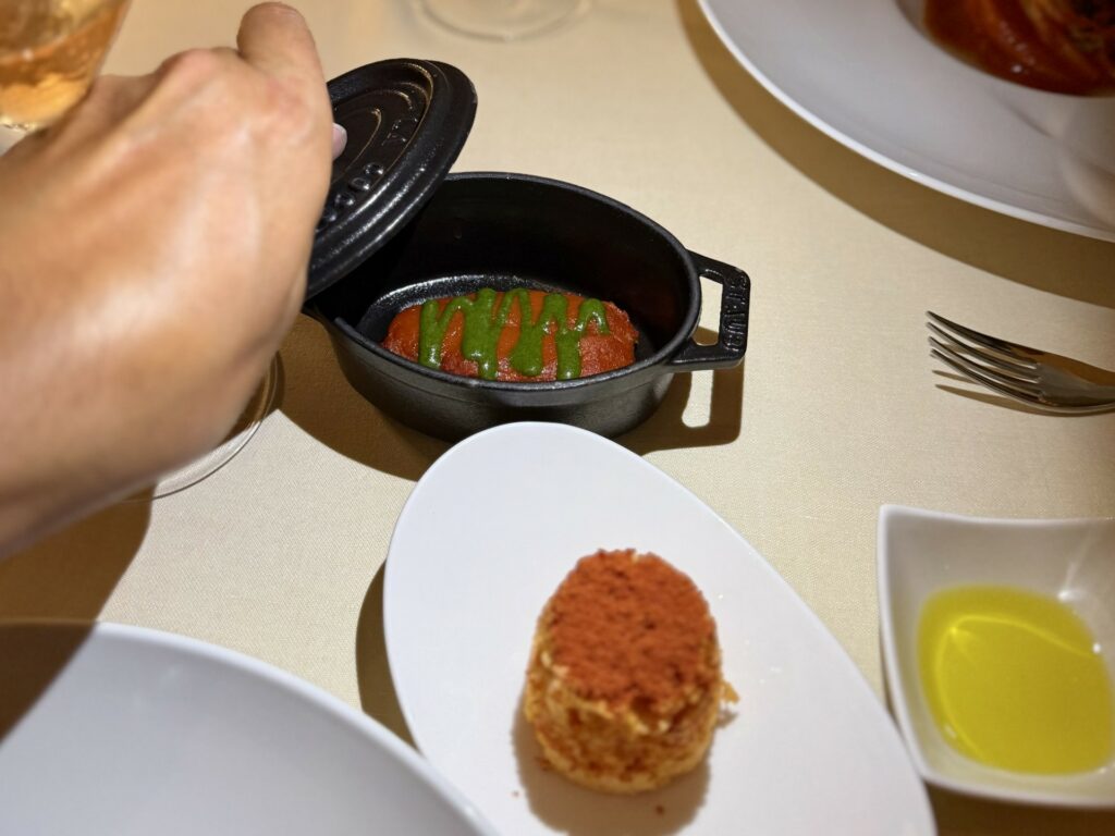 Una piccola cocotte in ghisa con all'interno del pomodoro.