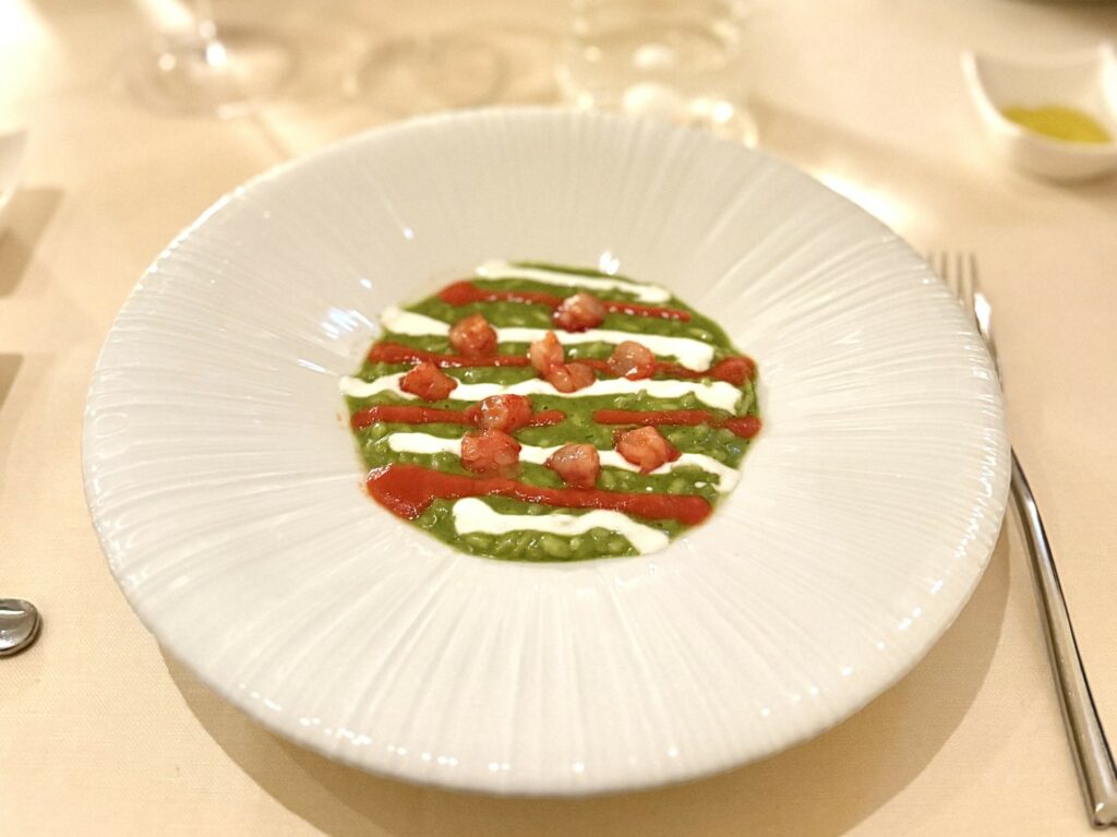Risotto al pesto di basilico napoletano, gamberi rossi ed emulsione di salsa pizzaiola.