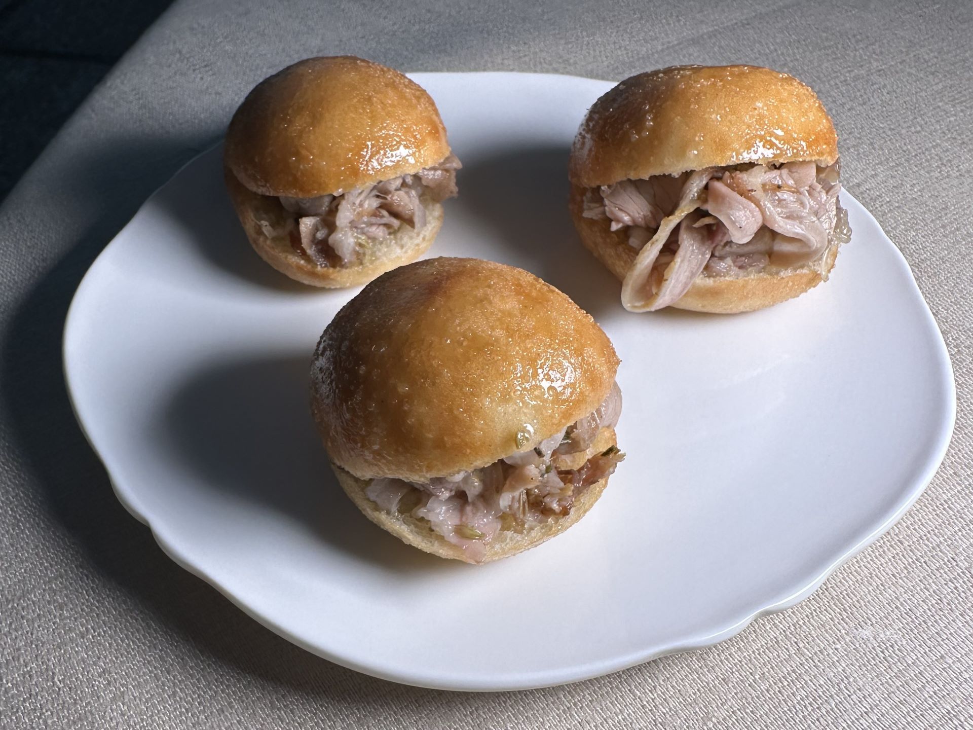 Bao fritti con porchetta di agnello e cipolla in agrodolce.