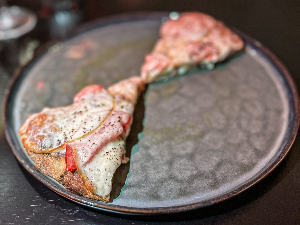 Pepe & provola Calabria School: pomodoro costoluto grigliato con olio al finocchietto, provola di vacca podolica affumicata, mozzarella e caffè polverizzato.