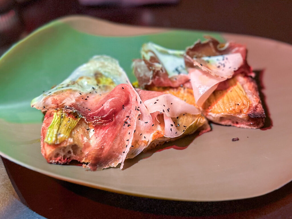 Fiori di zucca, mozzarella, tuorlo d’uovo pastorizzato a simulare una frittella, pepe , culatello di maialino e anice nero della Sila.