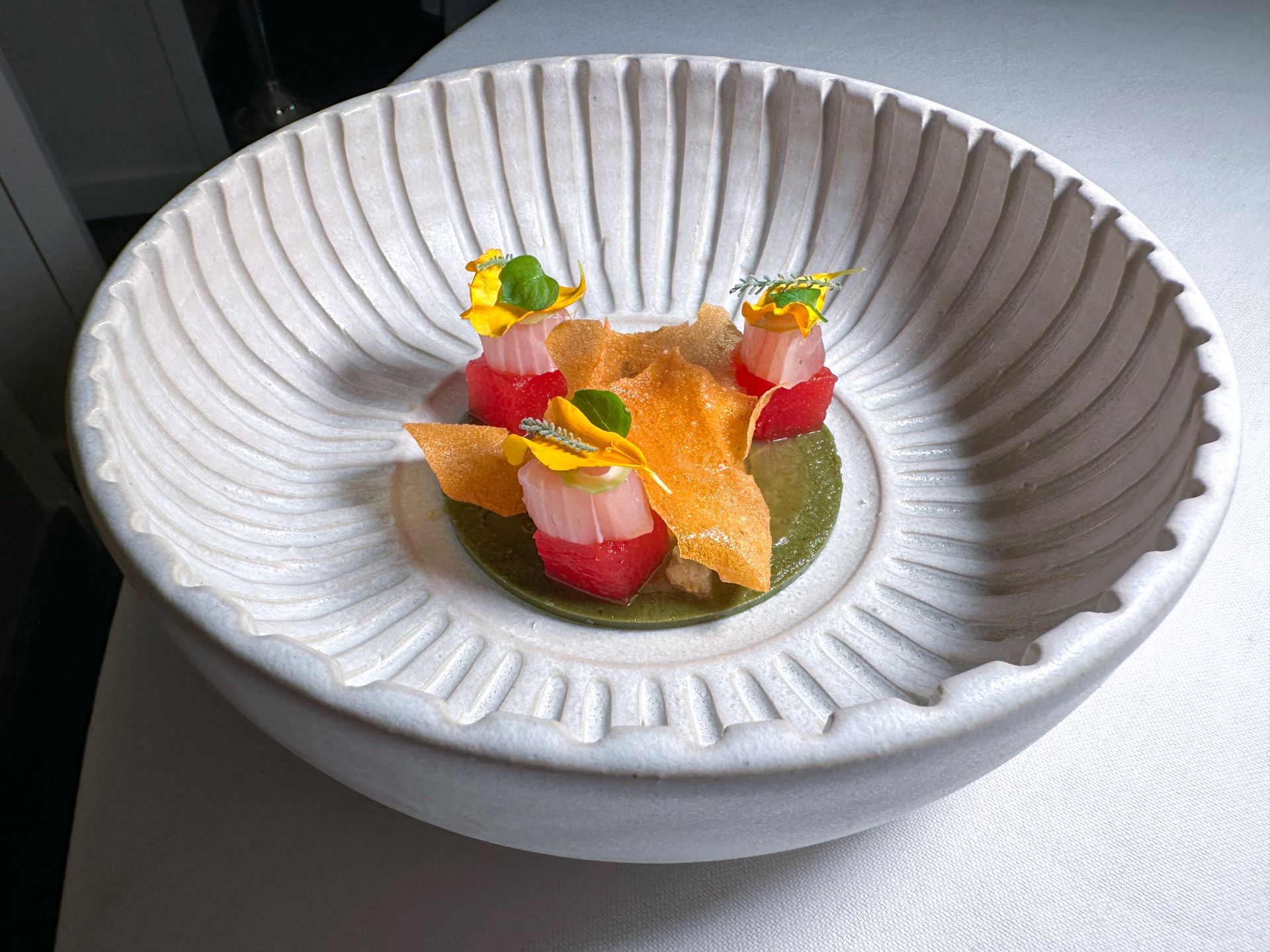 Crudo di ricciola, sfera melanzana affumicata, chips di pomodoro, ricotta, zuppa frutti di mare, verbena.