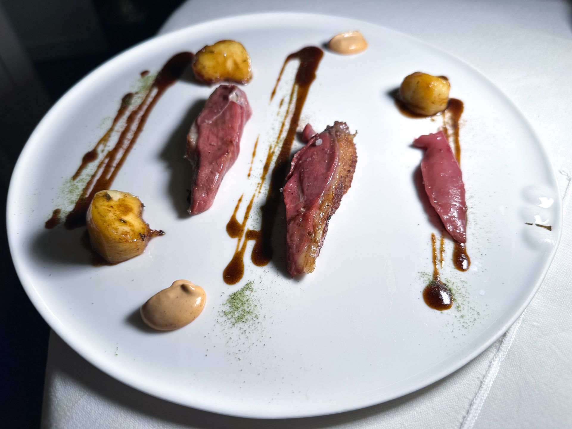 Piccione in foglia di fico, burro alle nocciole dell'Etna, ricci di mare, pesca e fico arrostito...