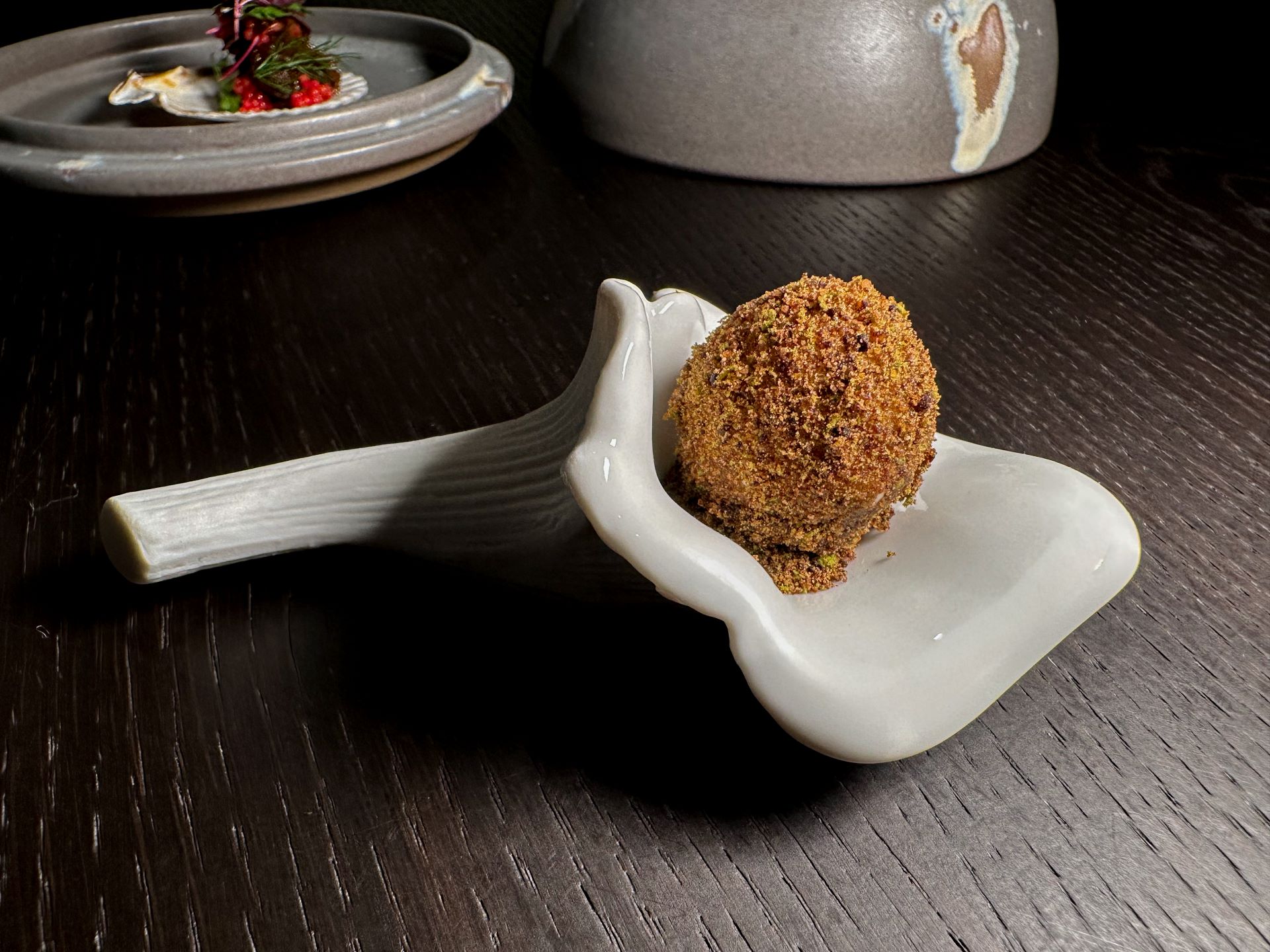 Sfera di acqua di pomodoro con polvere di pesto.