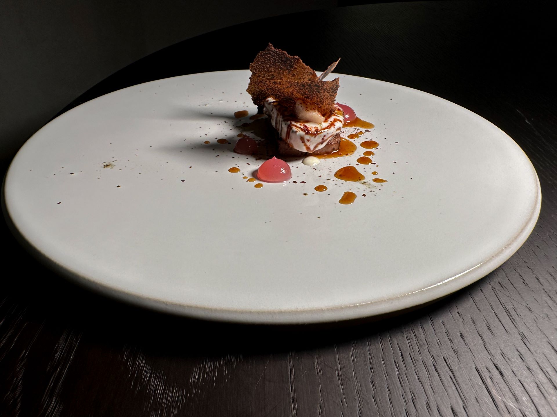 Pluma iberica farcita con anguilla, glassata con salsa d'anguilla ed emulsione BBQ, cialda di cipolla bruciata e gel di carpione di cipolla rossa, paprika affumicata e fondo di maialino.