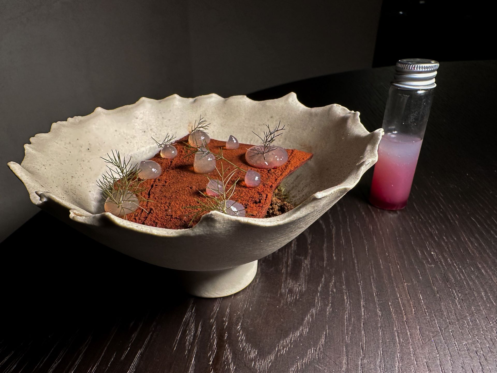 Spuma di cioccolato con gel di lampone, polvere di fungo porcino, terra al malto di orzo scuro, gel all'estratto di corteccia di pino del ristorante Rebis.