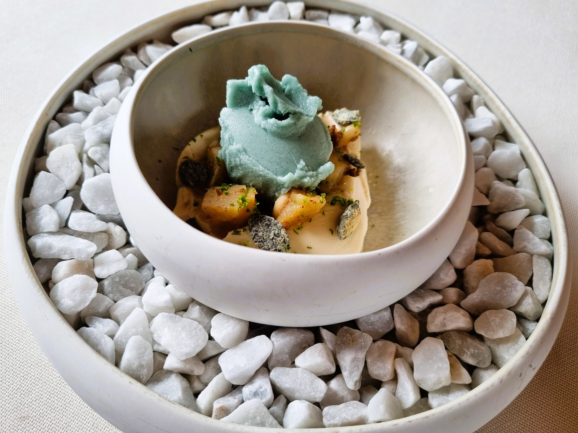 Cioccolato bianco, mele, semi zucca, sorbetto di torsolo di mela, semi di zucca macerati e ostrica del ristorante la tana gourmet.