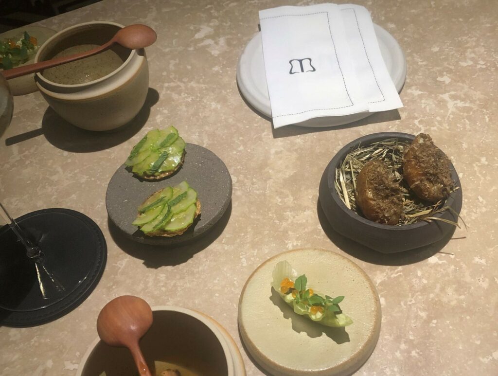 Amuse bouche del ristorante Al Madrigale: Trota marinata, olio erba cipollina, aneto, estrazione di datterino giallo e nespole
Patata della Marsica fritta, baccalà mantecato e tartufo estivo
Tartelletta di pane raffermo, crema di zucchine alla scapece, con zucchina fresche, menta
Foglia di lattuga crema di fave, uova di trota e cetriolini.