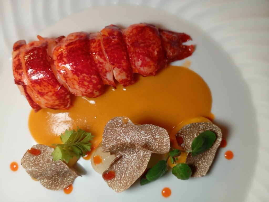 Astice blu, zucca korinki, cipolla borrettana, nduja, salsa mediterranea di pesce
con patate, pomodoro e capperi e tartufo nero.