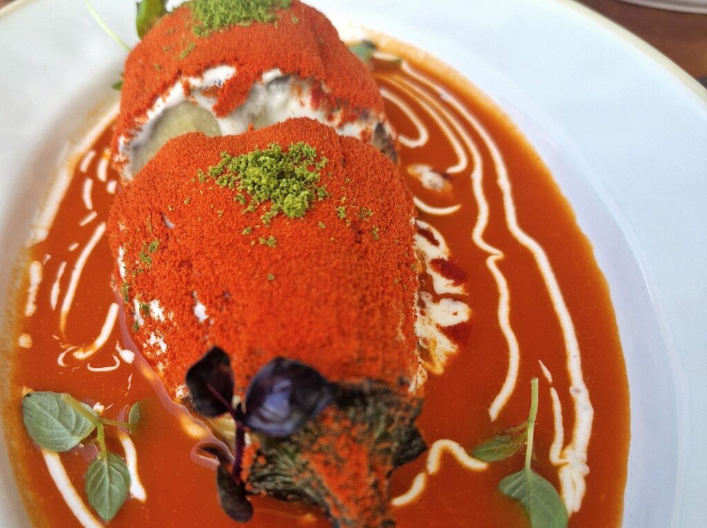 Parmigiana di melanzane con salsa di pomodoro datterino, fonduta di parmigiano reggiano, polvere di pomodoro, pesto liofilizzato.