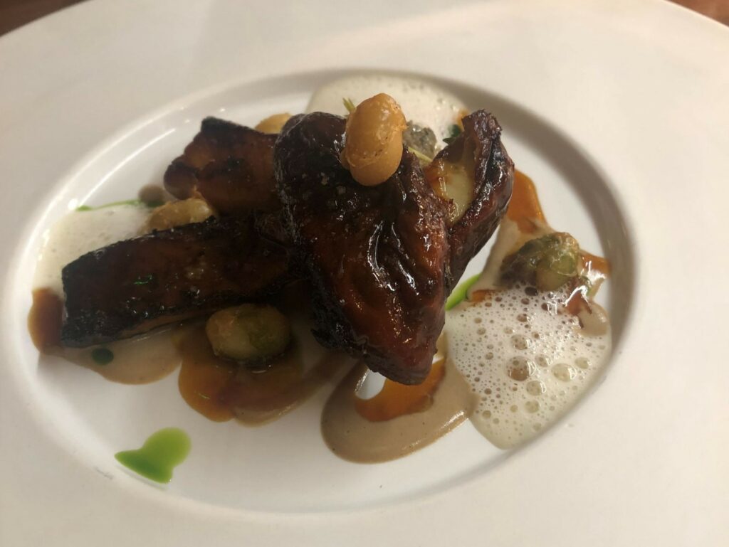 Porcini arrosto, vin Jaune, salsa all’aglio nero, fagioli di Paimpol croccanti