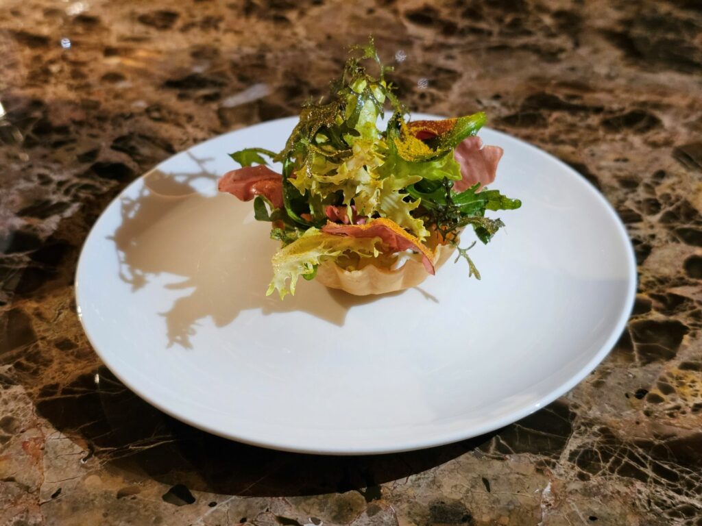 Tartelletta di caprino, salsa curry, insalata acida e amara