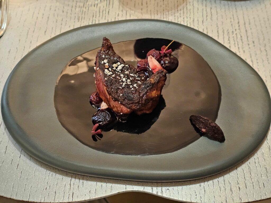 Piccione della Vendée laccato al miso, ciliegie confit, nocciole. A fianco, crema di scalogno e fegato