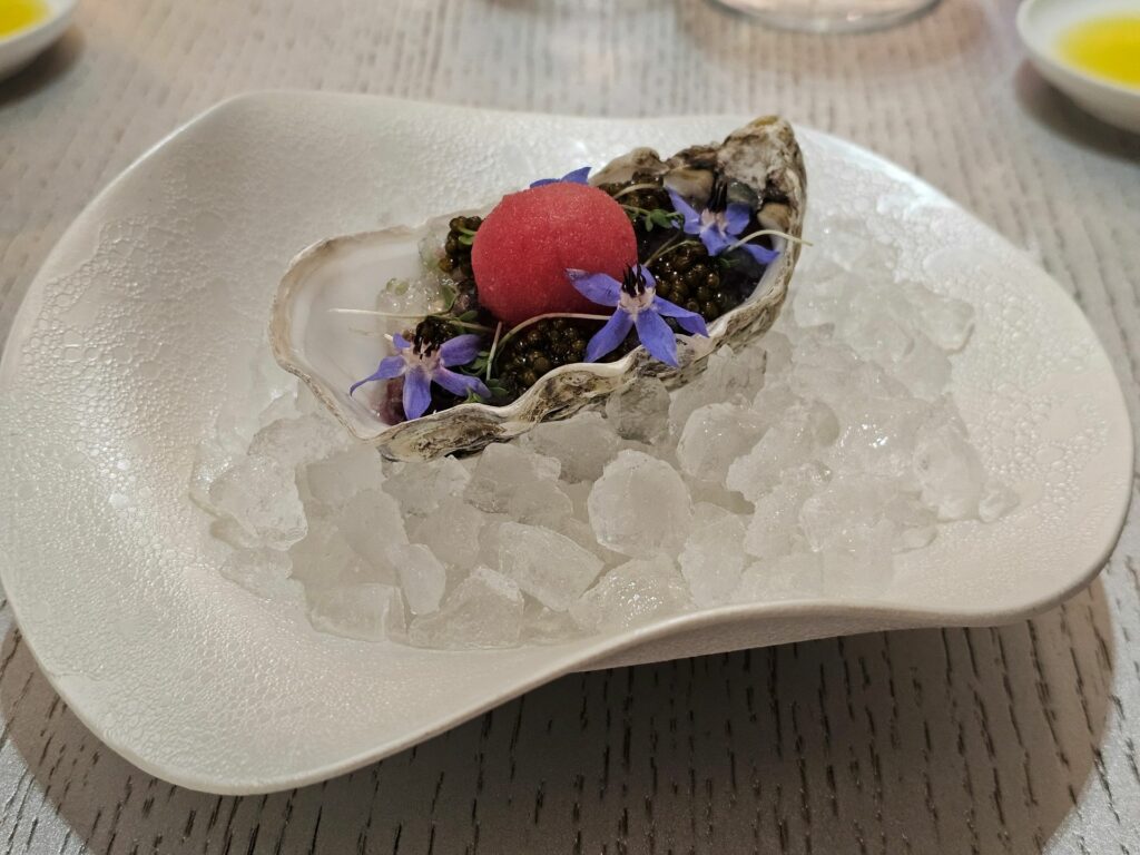 Ostrica Gillardeau N.1 cotta, caviale, sfera di sorbetto al pomodoro, fiori eduli
