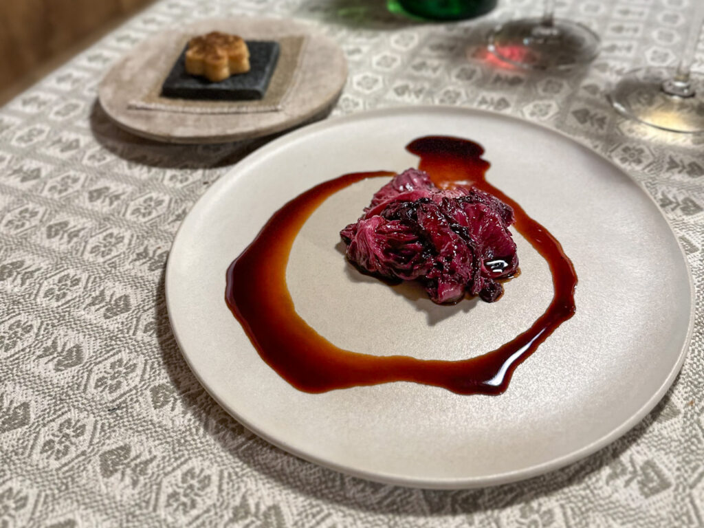 Purpureo amaro: Teres major caramellizzato con jus di umeboshi, radicchio brasato e cipolla bruciata.