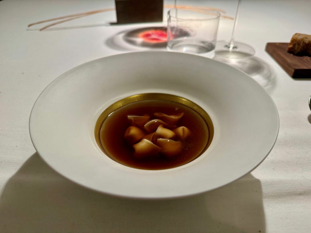 Ravioli di mandorla in brodo di bosco