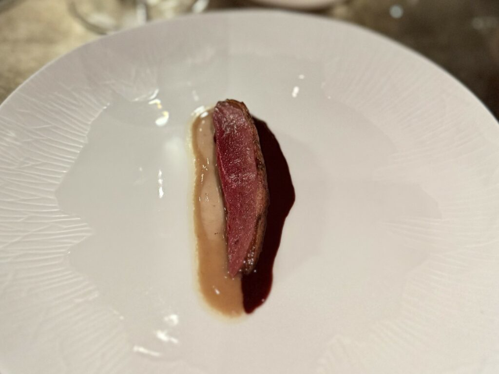 Germano reale alla brace, burro di acciughe, pepe rosa e jus salmì di radicchio.