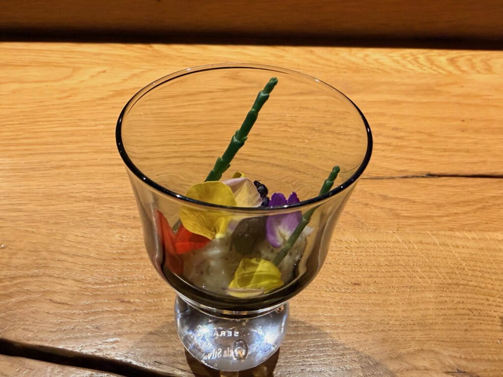 Scampo marinato, frutti rossi, ortaggi a radice e consommé al sommacco, fiori, pepe verde