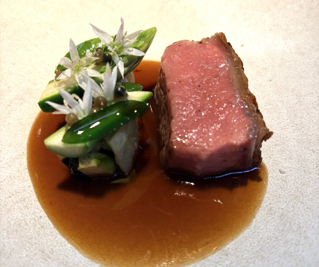 Agnello affumicato al ginepro, aglio orsino e asparagi verdi.
