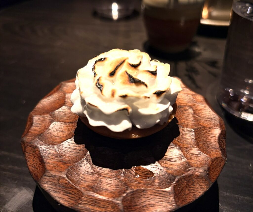 Meringa flambé, frutti di bosco sciroppati e semi di finocchio.