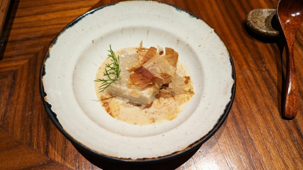 Tofu al sesamo, perle di dashi, salsa di sesamo.