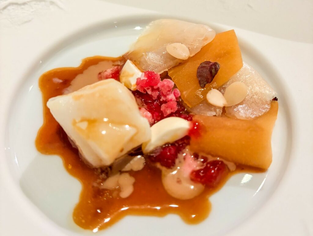 Branzino stagionato, kohirabi affumicato, mandorle selvatiche con tè nero e shiso viola di Lasarte