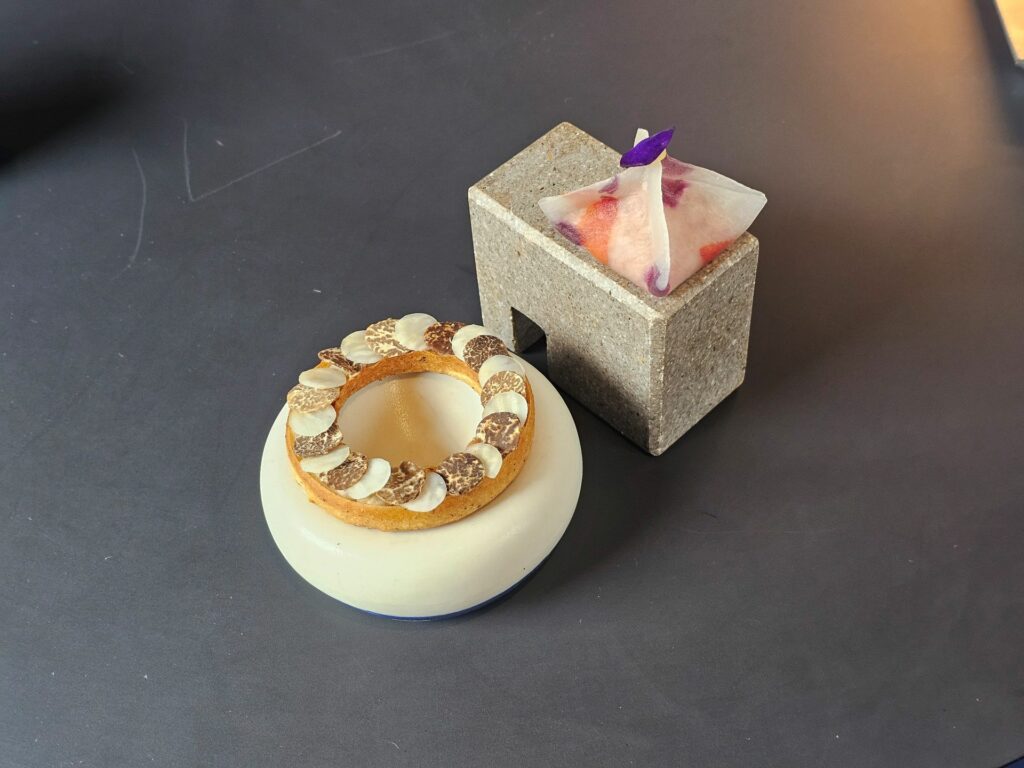 Benvenuto Agli Amici: ruota di tofu affumicato con sedano rapa e tartufo nero; origami di tartare di Chianina.