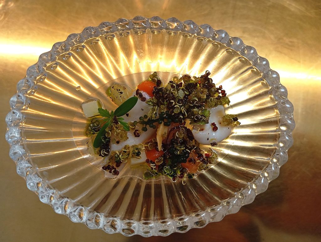 Insalata di conchiglie marine, uva di mare e quinoa soffiata al plancton
